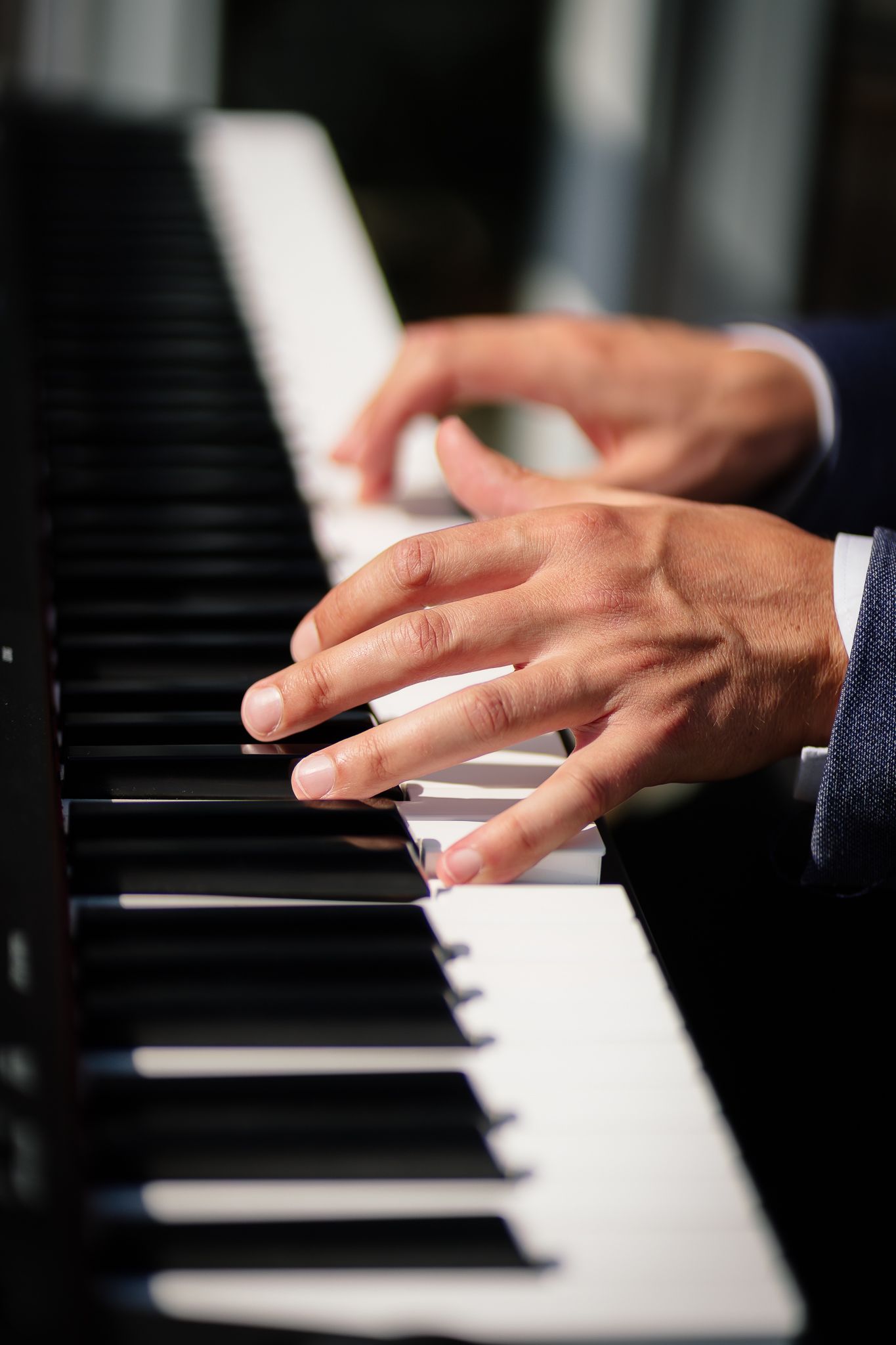 Hands gliding across black and white piano keys in a sequential progression of close-up shots.