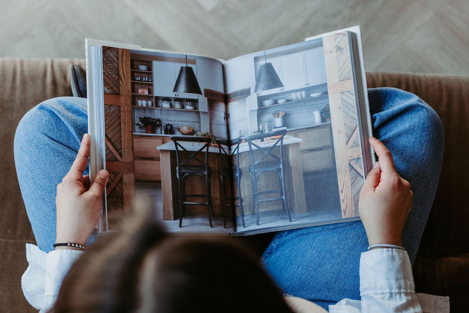 Someone holds and browses through a photo album or book displaying black and white photographs.