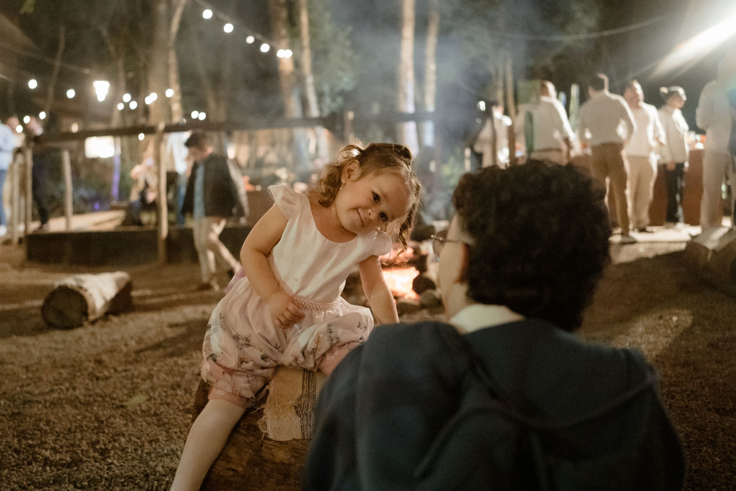 A magical moment at a wedding reception with string lights and dancing outdoors.