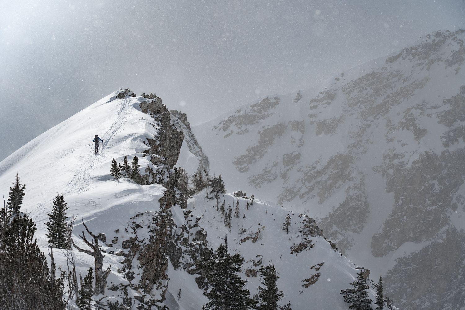 Two snowboarders riding down a slope