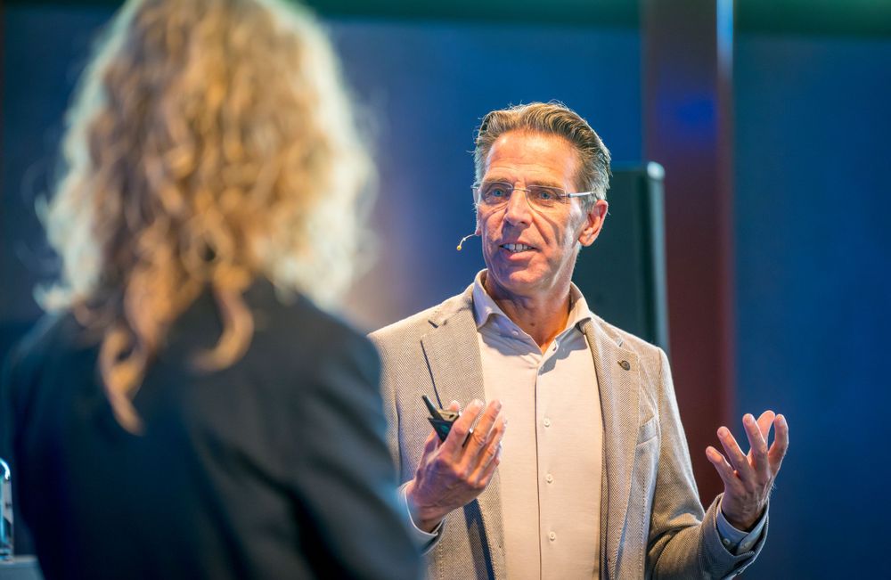 Business conversation between two people during professional networking event with blue lighting.
