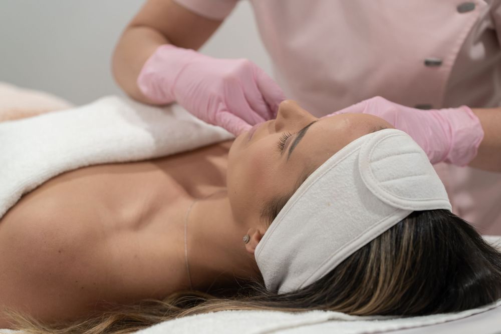 Side view of spa facial treatment with client wearing protective headband.