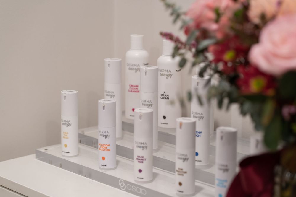 Collection of skincare products displayed with floral arrangement in spa setting.