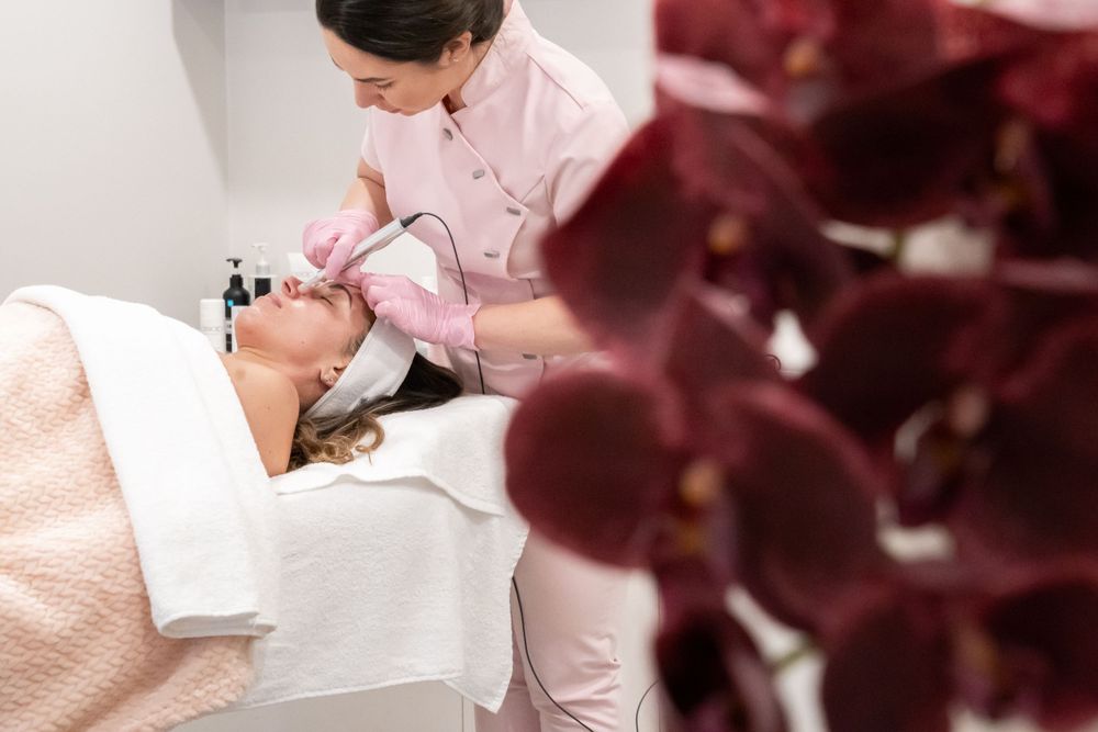 Professional aesthetician performing precise facial treatment on client in spa setting.