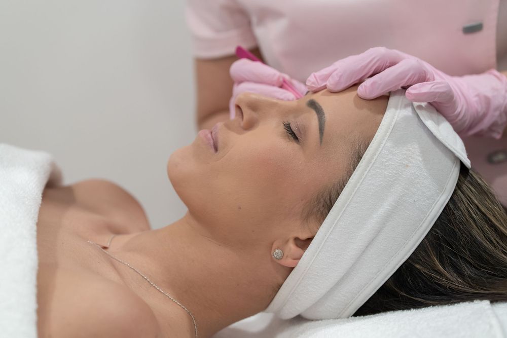Professional skincare treatment being performed with client wearing white headband.