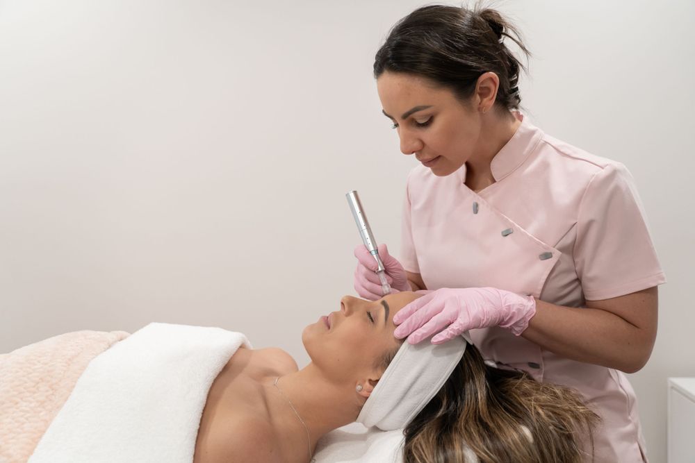 Spa technician in pink uniform performing precise facial procedure on client.
