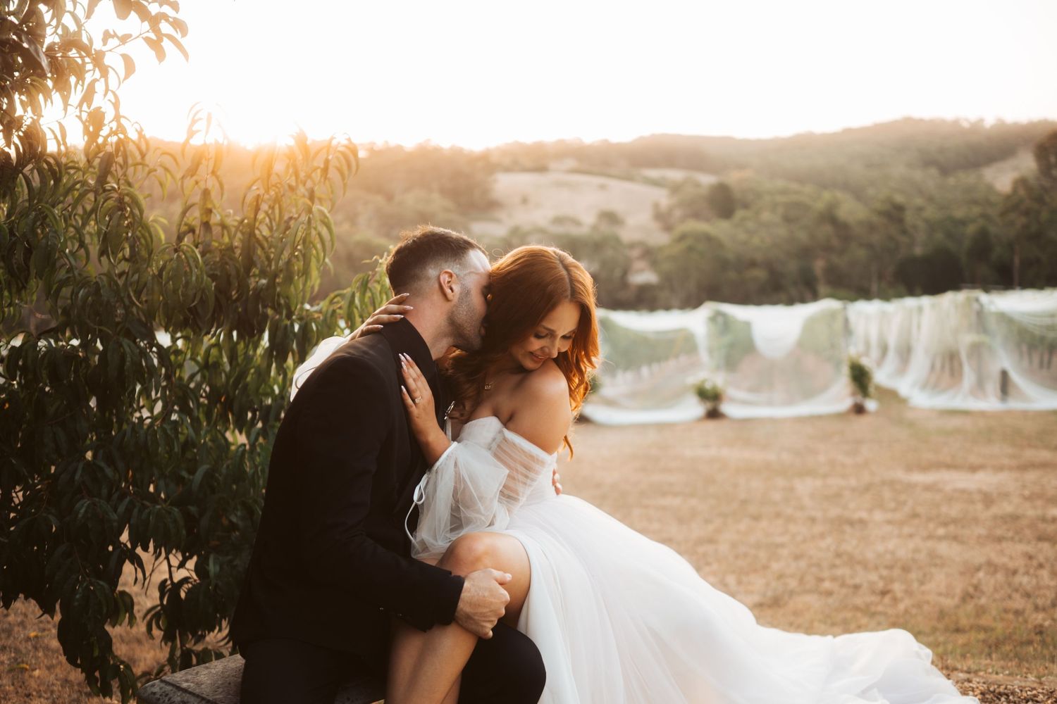 Sunset wedding portrait with vineyard and rolling hills backdrop