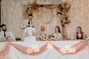 Wedding reception head table decorated with fairy lights and dried floral arrangements.