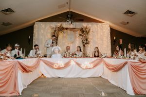 Wedding reception tables decorated with pink and white linens and floral centerpieces in an elegant banquet hall.