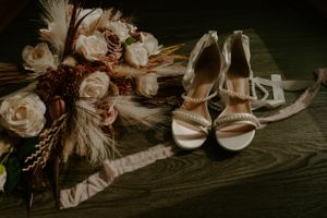 Dried pampas grass and floral wedding decorations against rustic backdrop.