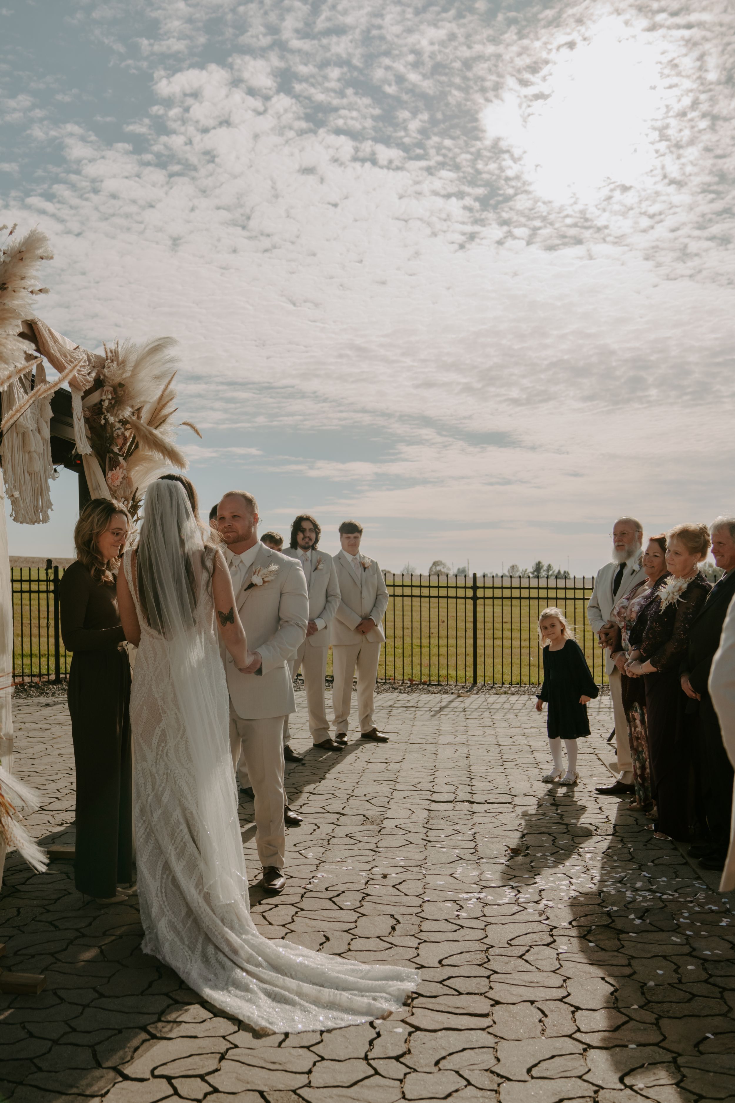 Wedding ceremony on a stone patio with guests watching the celebration unfold.