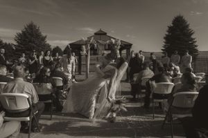 Black and white photo of wedding guests mingling at outdoor reception venue.