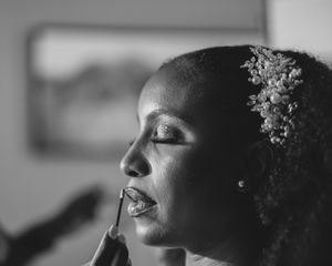 Artistic black and white bridal portrait with soft lighting and floral hair accessories.