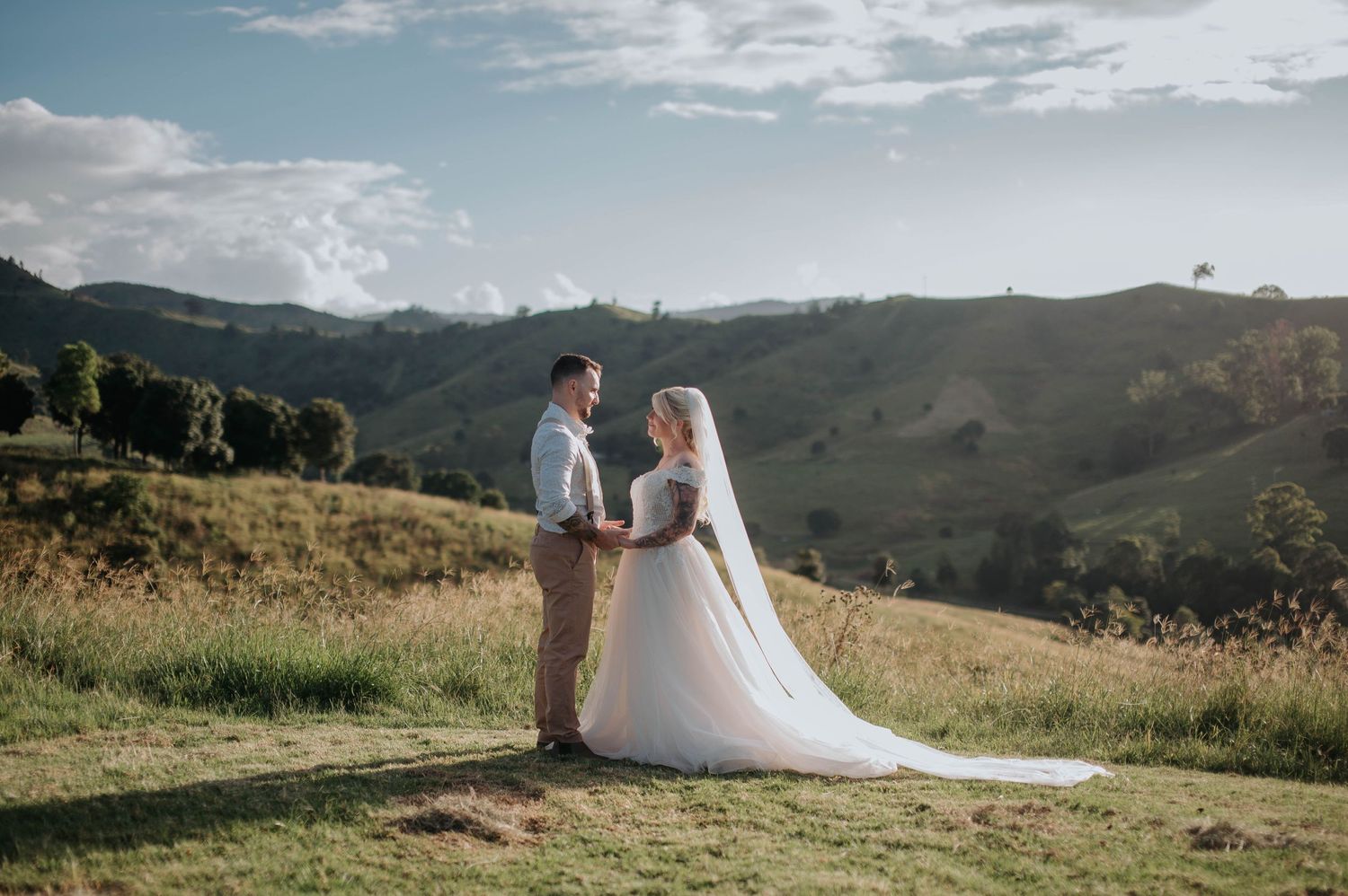 Bride and groom standing together on scenic mountain overlook.