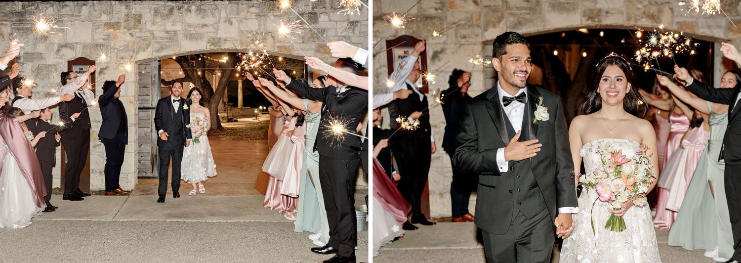 Newlyweds walk through sparkler exit tunnel surrounded by guests in rustic stone venue.