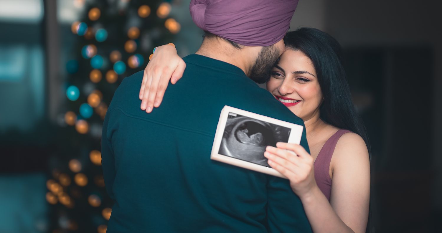 intimate couple with the scan image of their baby showing deep emotions on a maternity shoot.
