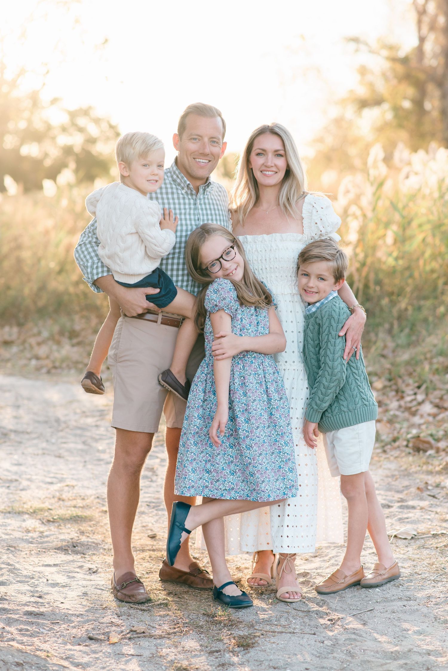 Family of five cuddles together for a photo taken by Lauren Marie Photography on a sandy beach path in Monmouth County, NJ.