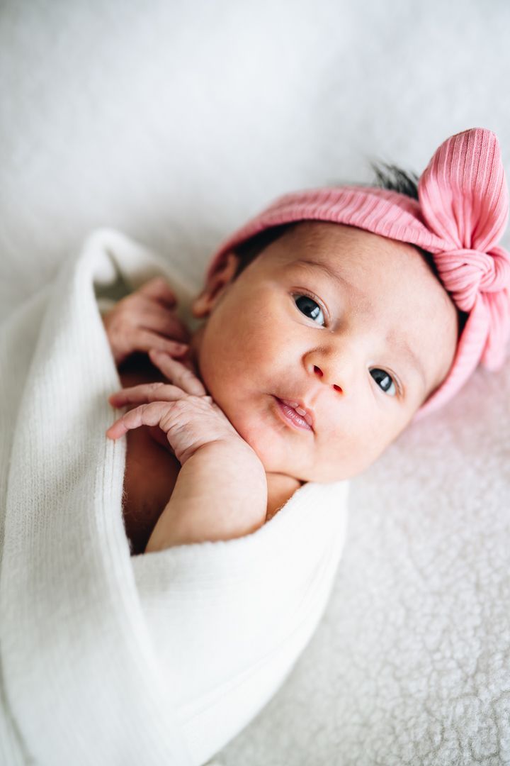 Newborn looking at the camera sweetly during a newborn photoshoot at home by Melbourne newborn and family photographer Pei A Photography