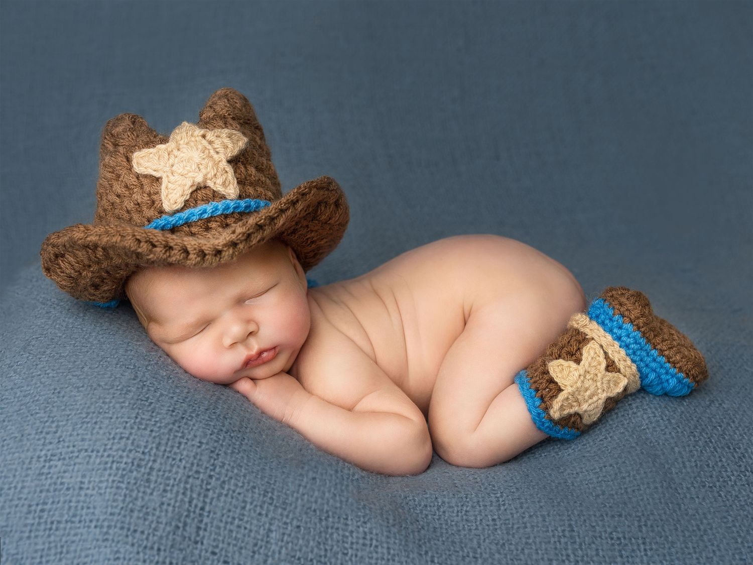 A beautiful sheriff is in town. Gorgeous baby boy posing on the table for his first photo