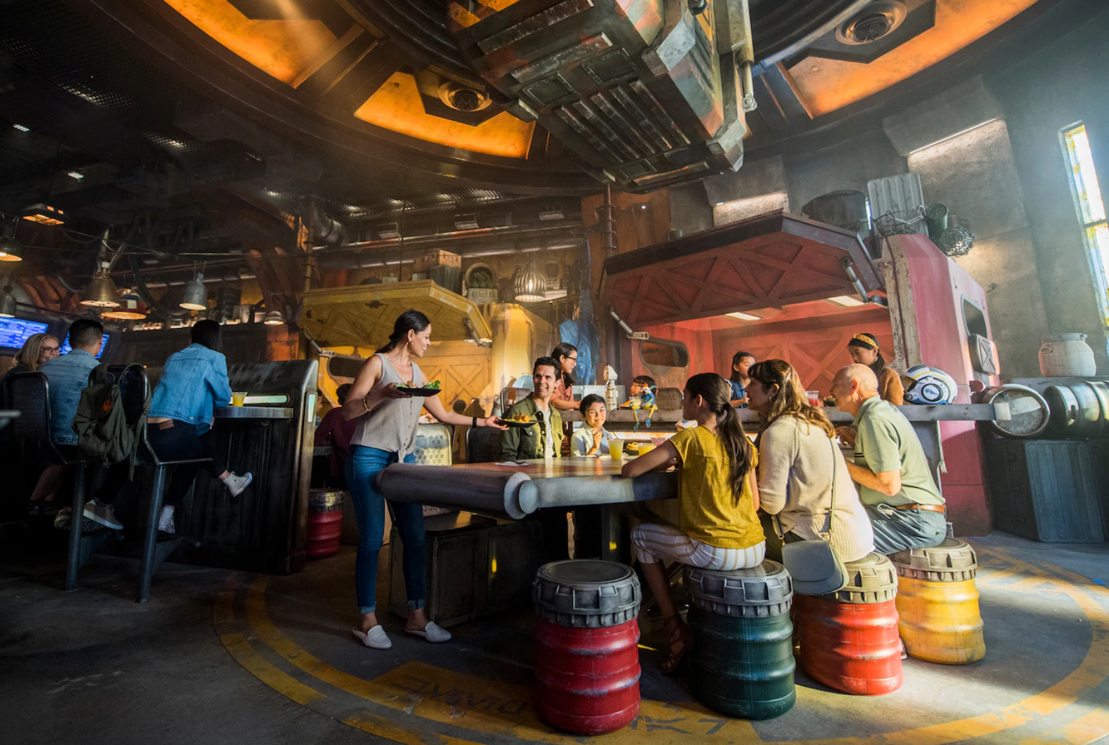 Vibrant themed restaurant interior with industrial decor and colorful barrel seating.