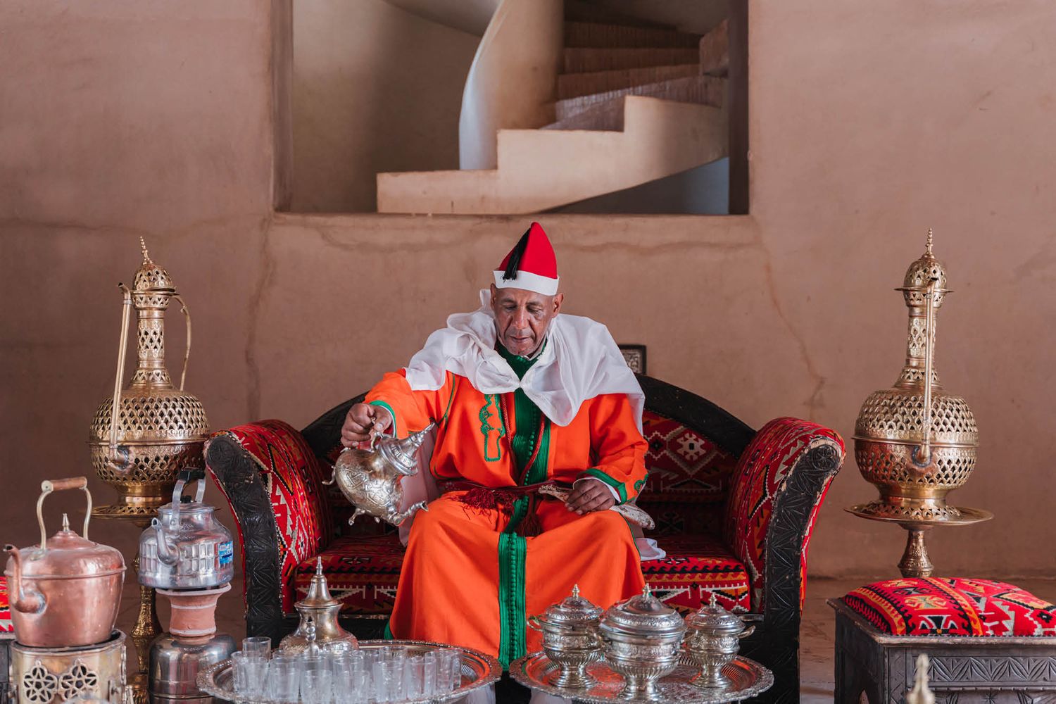 A festive scene with traditional Moroccan decor featuring ornate silver teapots and a cozy seating area with holiday decorations.