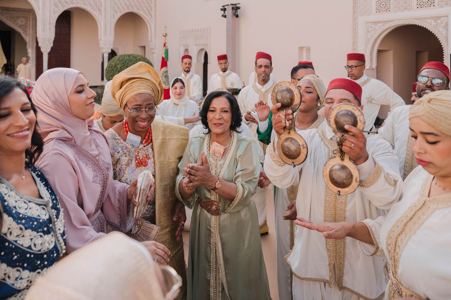 A festive group celebrates during a traditional Moroccan wedding ceremony with decorative elements and cultural attire.