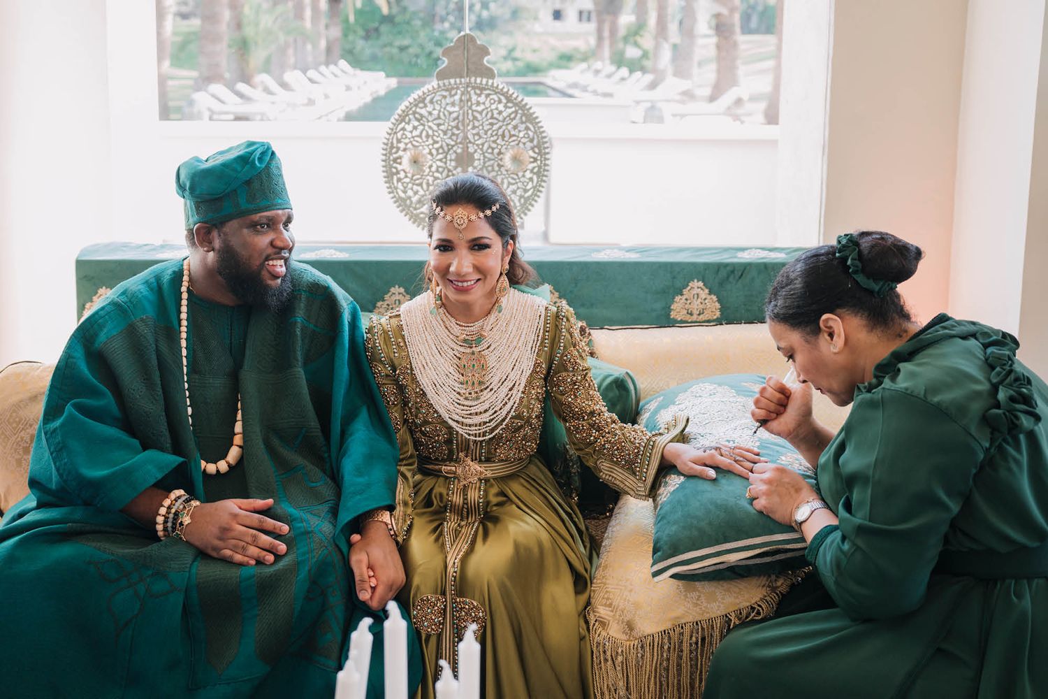 A couple in traditional Nigerian wedding attire sharing an intimate moment with a wedding planner in emerald green.