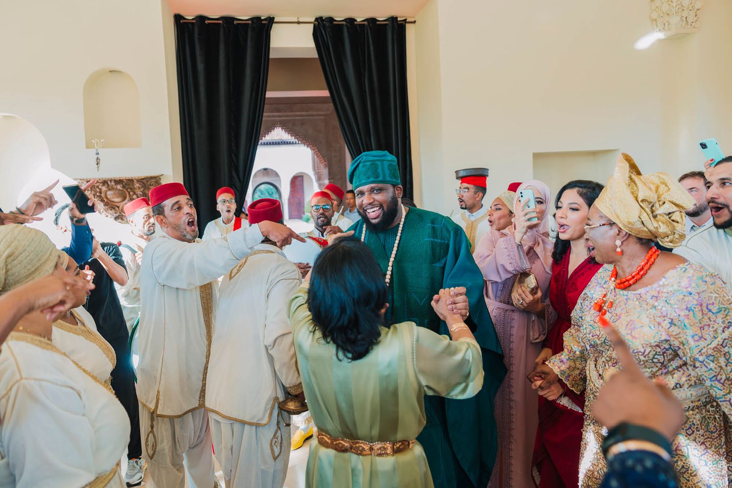 A joyous celebration with traditional Moroccan dress and decor in an indoor gathering space.
