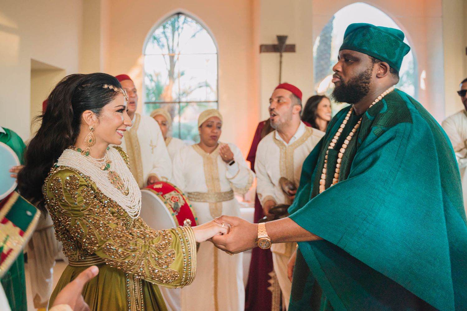 Religious ceremony in a church with clergy member in emerald green robes greeting congregant in gold dress.