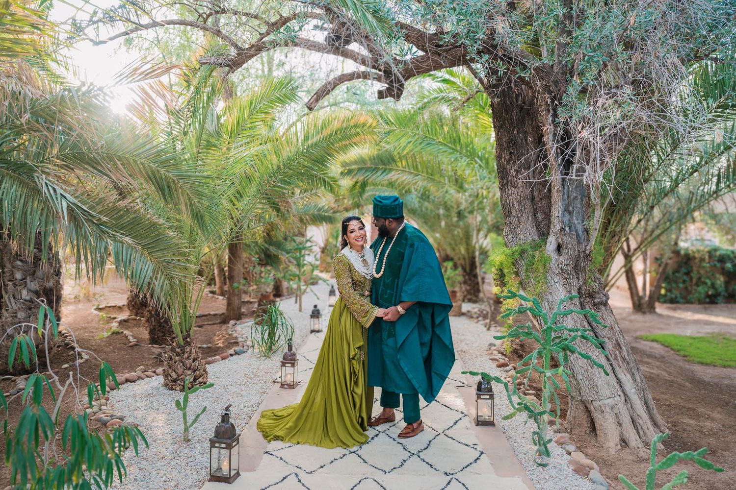 A romantic garden photoshoot featuring traditional formal wear and ornate lantern decorations along a stone path.