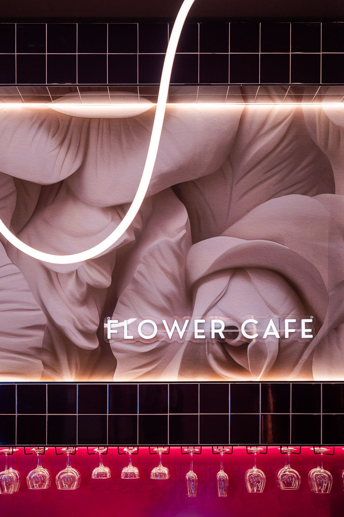 Illuminated Flower Café feature wall with floral artwork, bold lighting, and glassware creating a stylish, modern interior atmosphere.