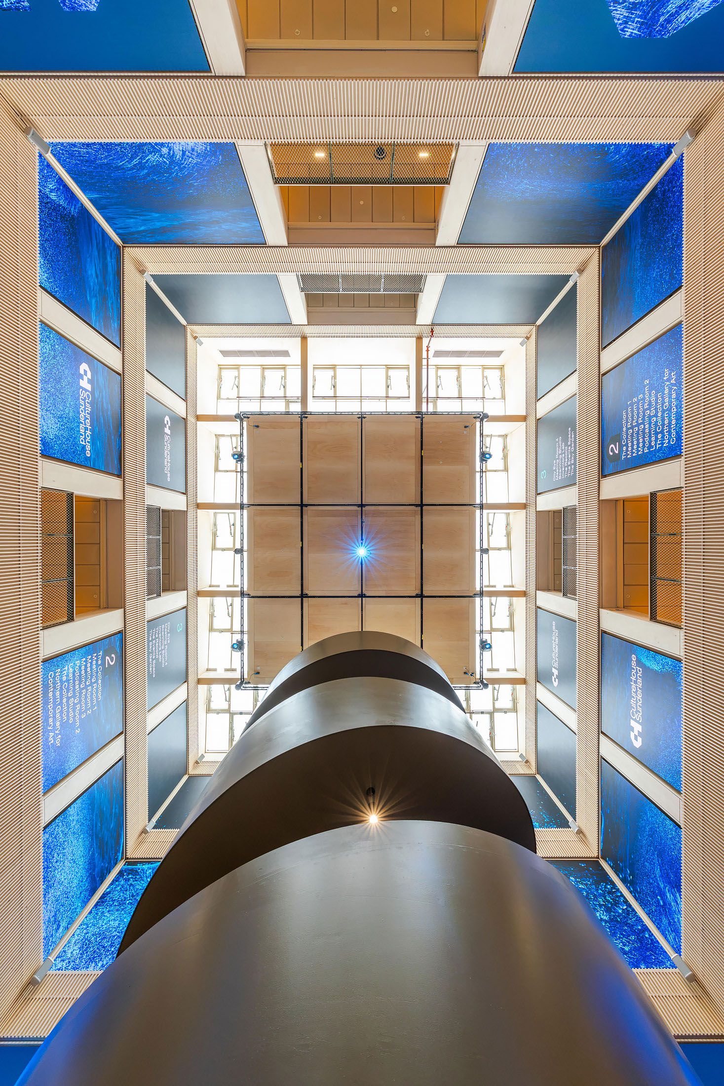 vertical view contemporary curved staircase with illuminated steps in a modern cultural centre interior.