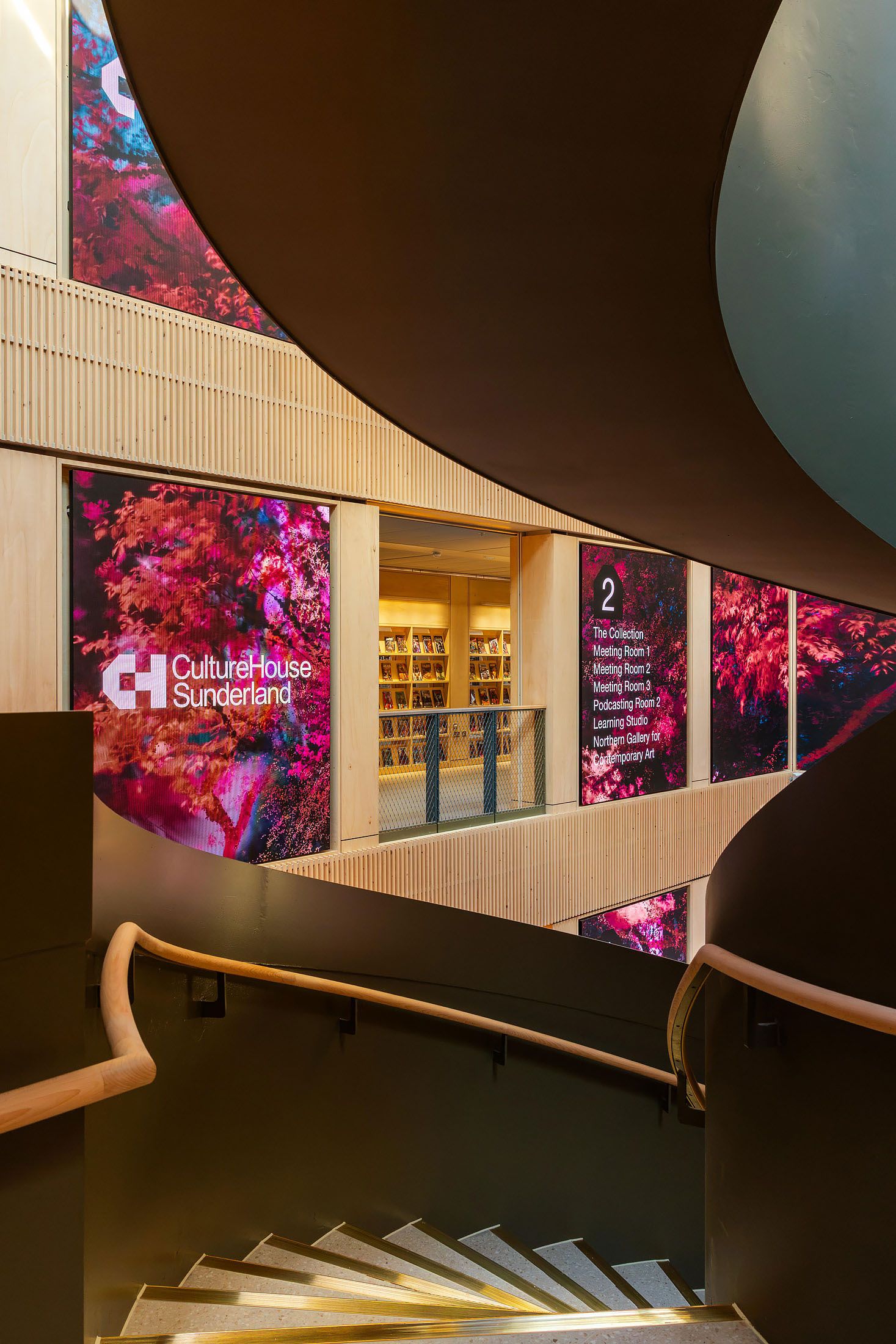 Culture House in Sunderland's contemporary curved staircase and vibrant digital artwork displays in a modern cultural centre interior.