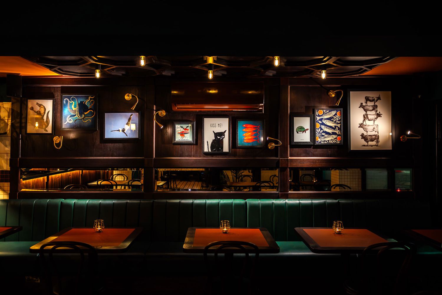 Elegant dining area with teal booths, eclectic artwork, warm lighting, and a cozy atmosphere for an intimate dining experience.