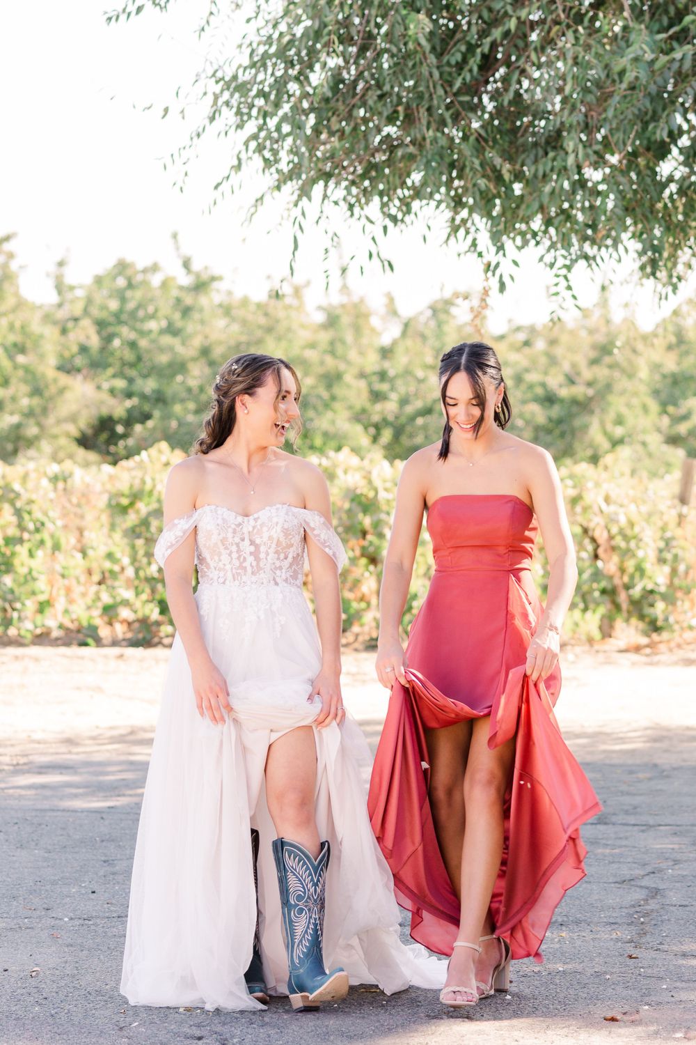 Wedding party shows off their footwear while lifting their burgundy and white dresses.