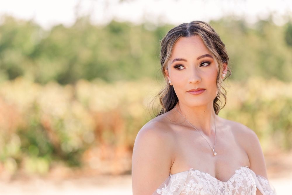 A romantic outdoor wedding photoshoot featuring a bride in a delicate lace gown with natural sunlit background.
