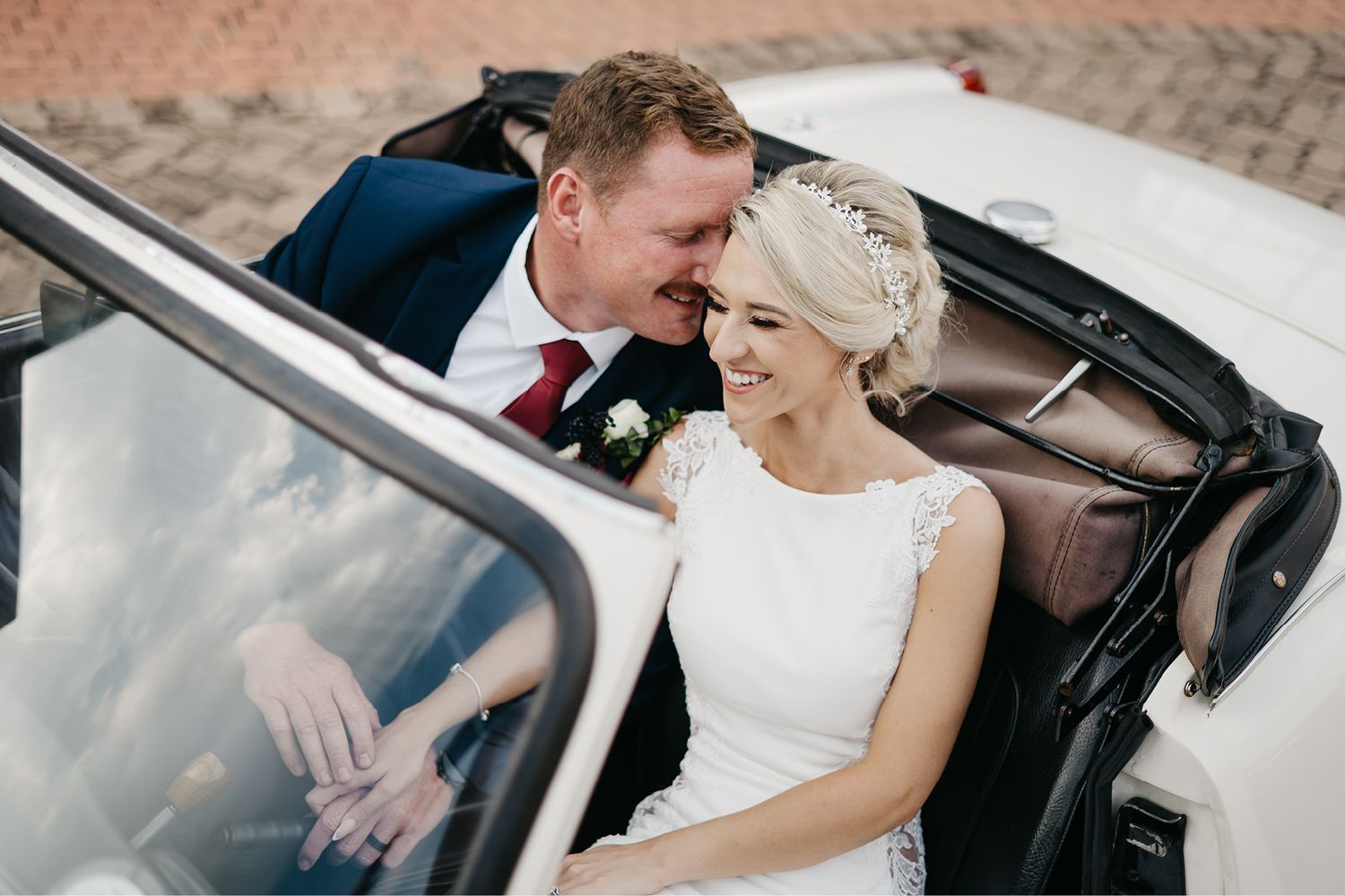 bride and groom sharing a laugh in a vintage wedding car at Candlewoods boutique venue in South Africa