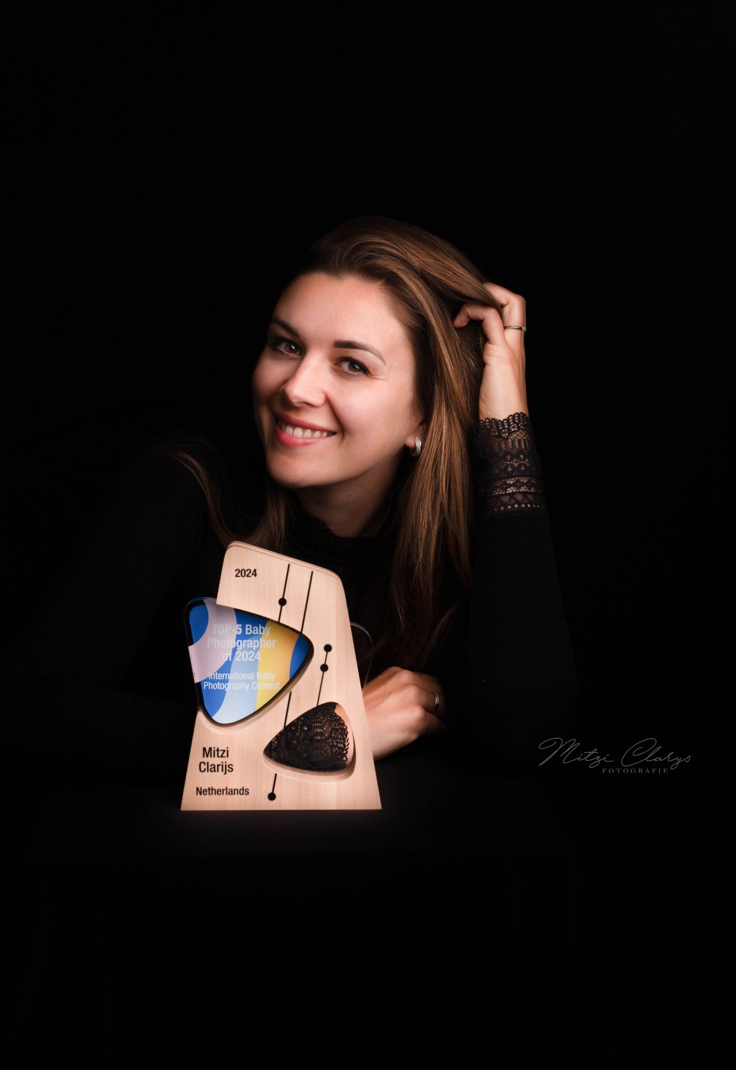 Fotograaf Mitzi Clarijs met award in studio, Goes