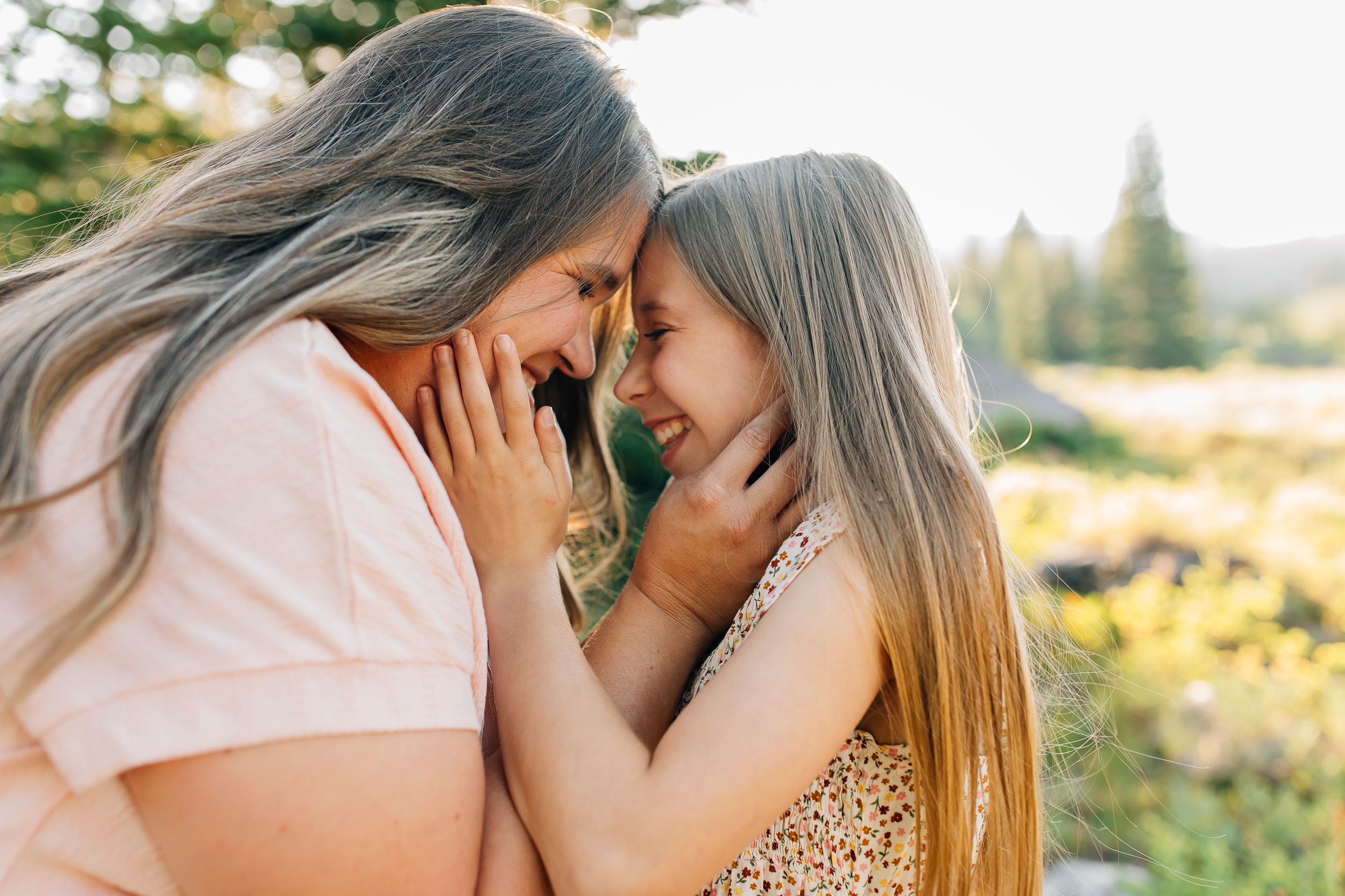 An intimate moment between two people touching foreheads in golden afternoon light.
