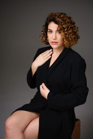 Artistic studio photograph featuring black wrap dress and natural styling.
