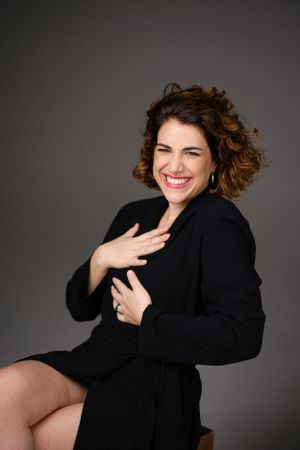 Candid studio portrait showing joyful expression and natural curls.