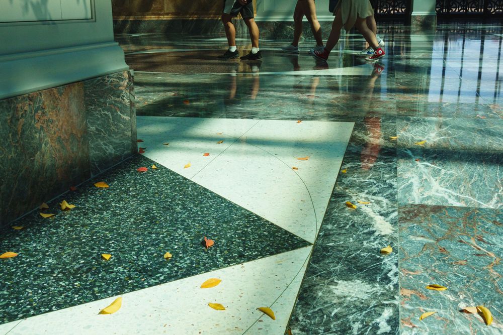 Geometric floor pattern with fallen leaves in modern building interior.