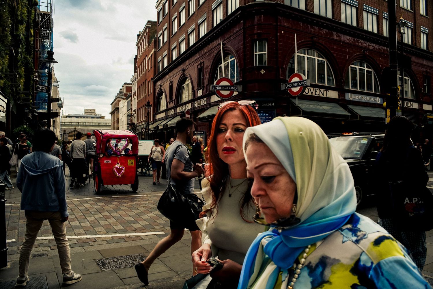 Street scene in a bustling urban area with colorful clothing and storefront displays.