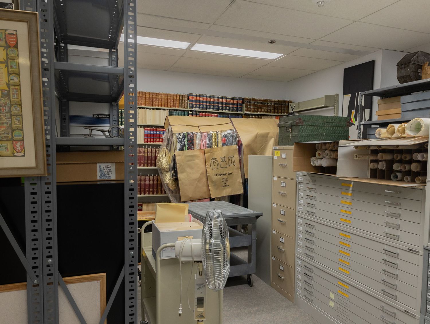 Library archive storage room with flat file drawers, shelving units, and rolled document storage.