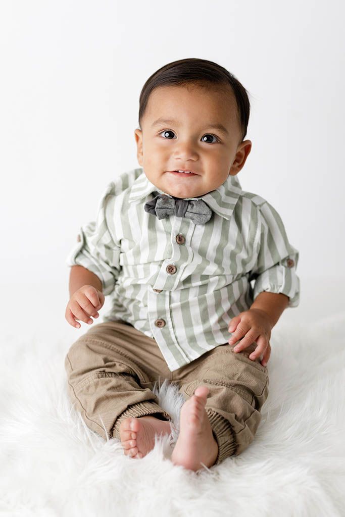 Adorable baby boy in a bow tie smiling for a milestone photo session by Lake Elsinore 1st birthday photographer .