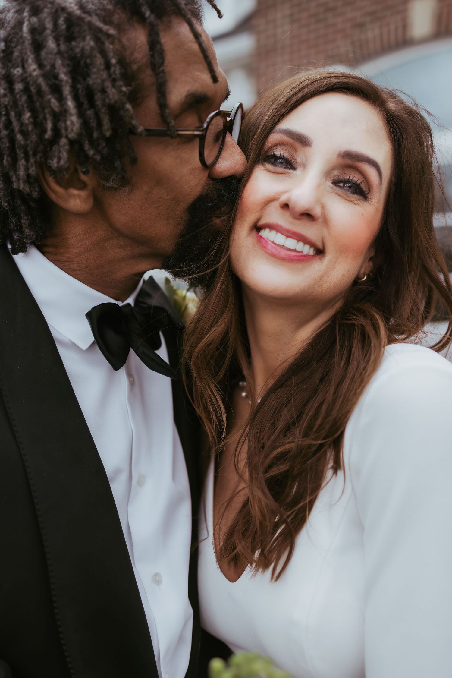 Bride and groom, wedding portrait kissing on a windy day at Holliday Farms in Zionsville, Indiana