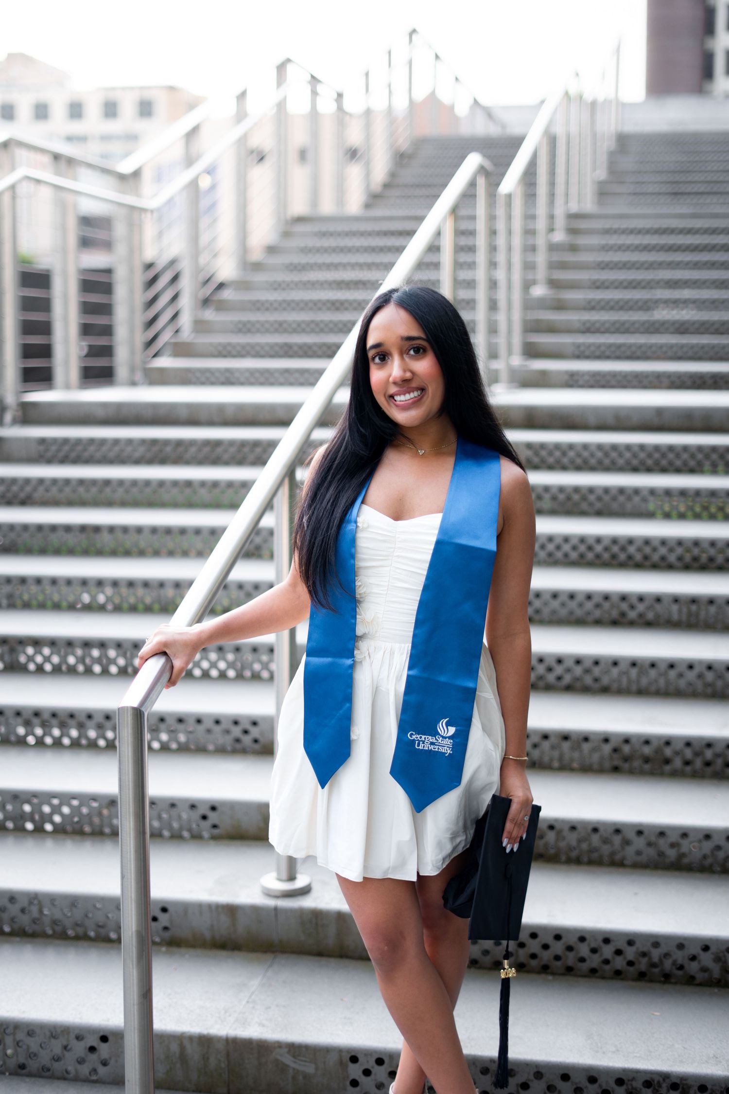 Smiling graduate poses for the best Atlanta grad photos at Georgia State University with portraits by Pierre The Pear Photography