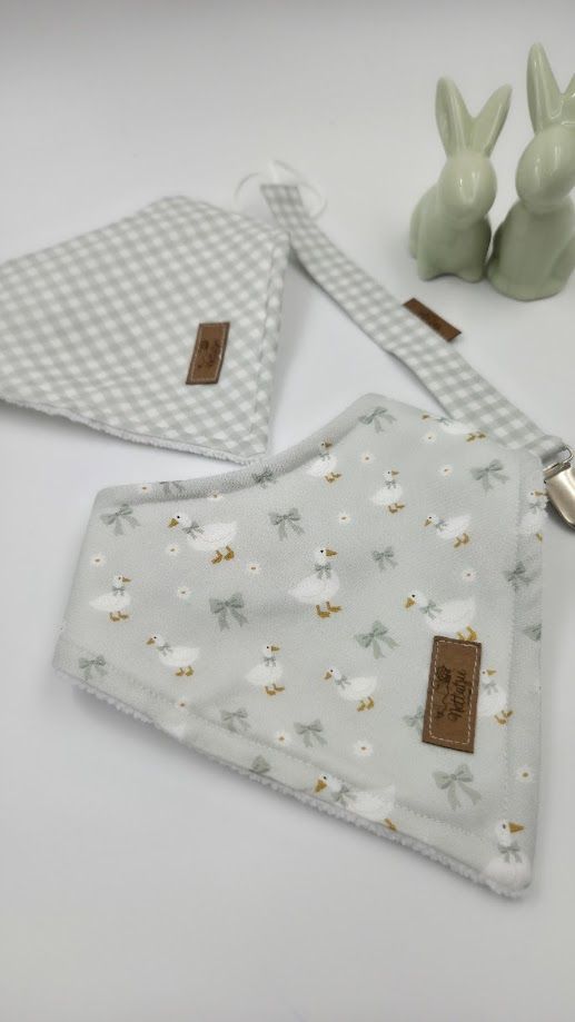 Soft mint baby gift set with gingham pacifier clip, bunny print muslin, fluffy blanket, and ceramic rabbit figurines in a wooden box.