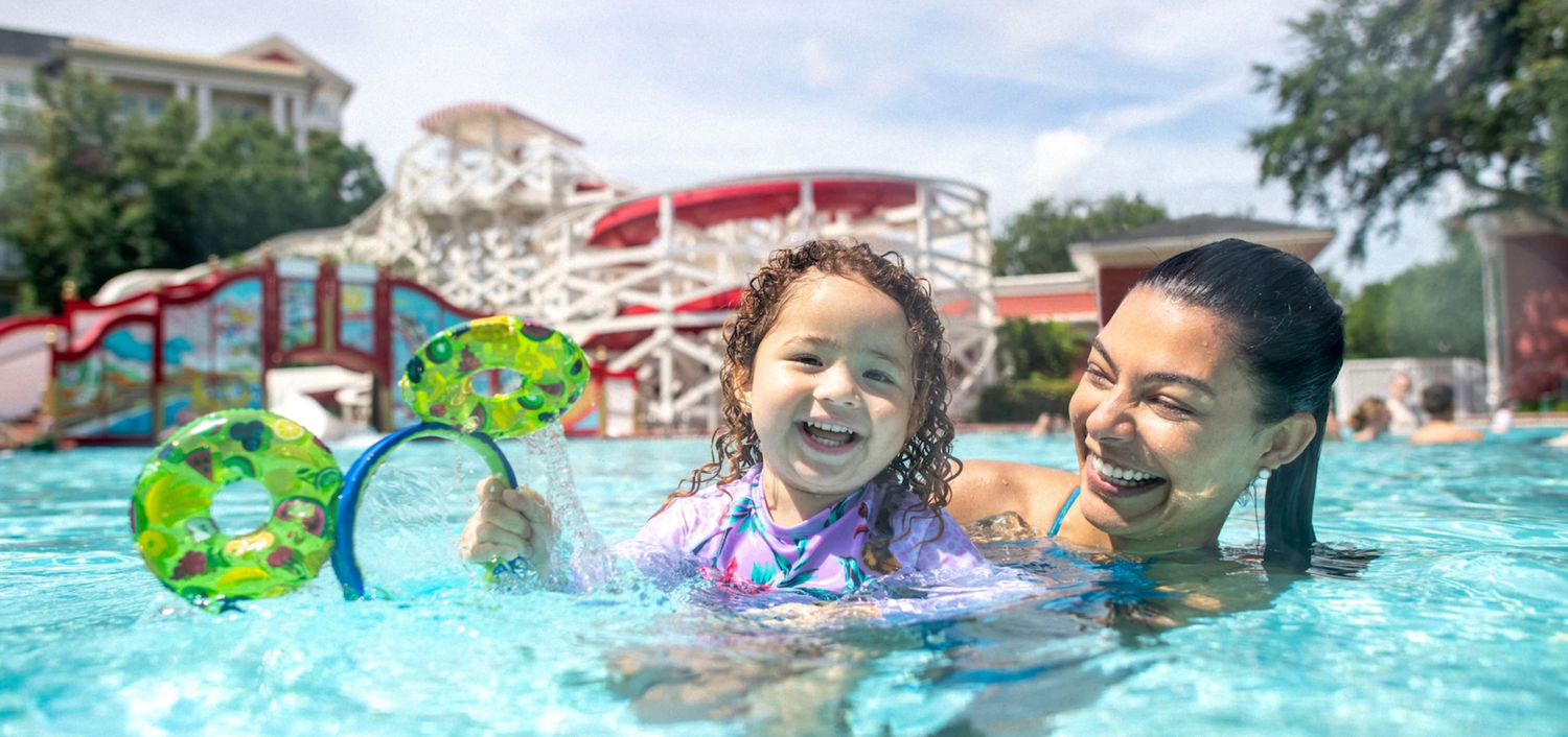 Pool area with water slides and play features at a family resort.