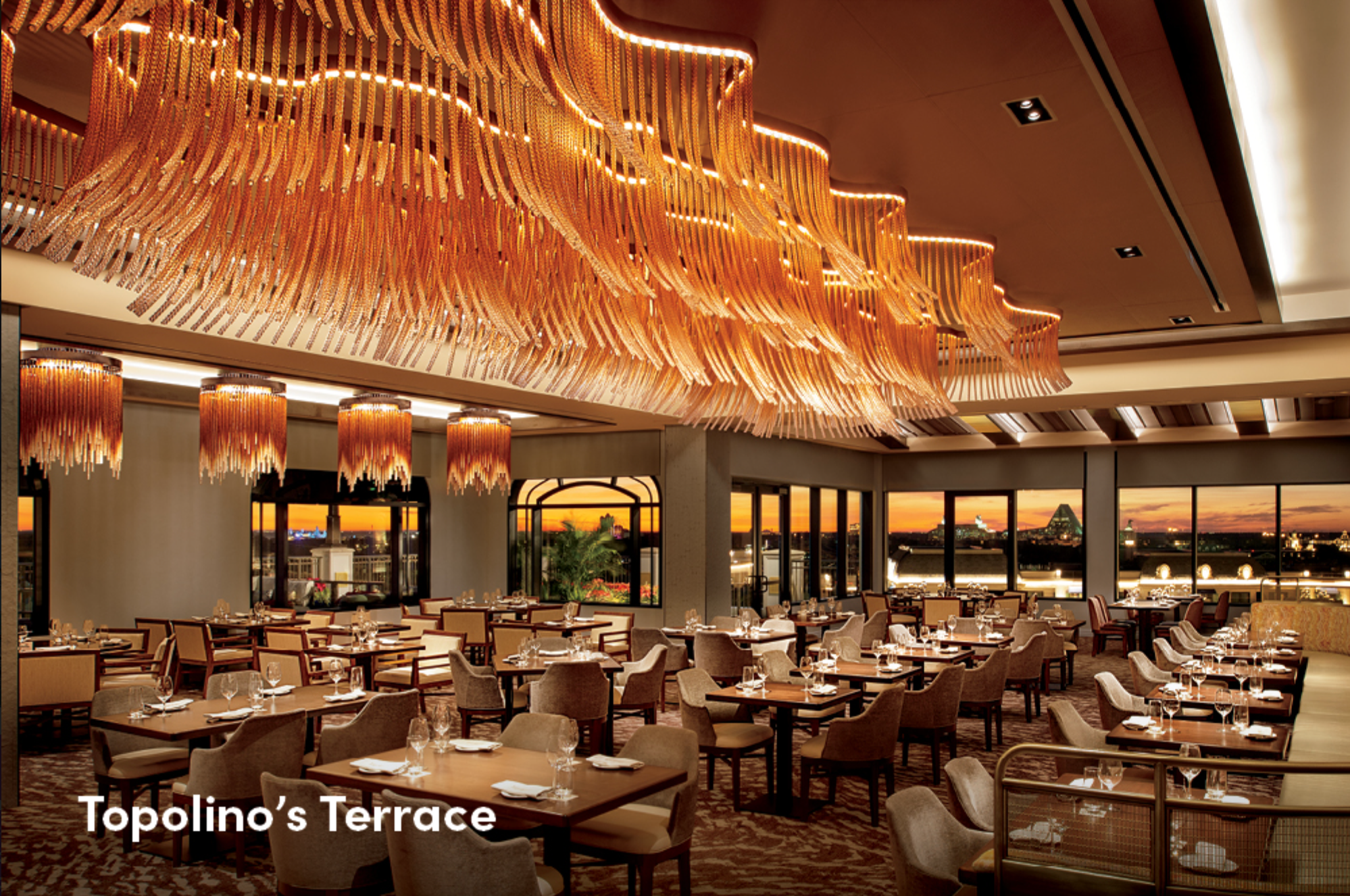 Elegant restaurant interior with dramatic wave-like ceiling lights and formal dining setup.